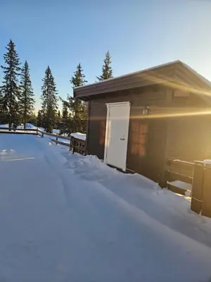 a building with a door in the snow at Hytte i Ringsaker (Ljøsheim/Sjusjøen) in Ringsaker