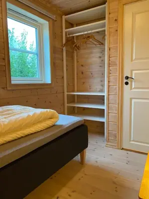 a bedroom with a bed and a window and a closet at Hytte i landlige omgivelser på Hadeland in Gran