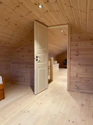 an empty room with a door in a room with wooden walls at Hytte i landlige omgivelser på Hadeland in Gran
