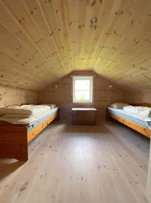 a wooden cabin with two beds in a room at Hytte i landlige omgivelser på Hadeland in Gran