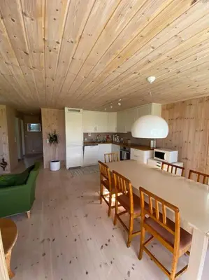 a kitchen with a large table with chairs and a dining room at Hytte i landlige omgivelser på Hadeland in Gran