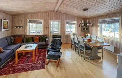 a living room with a couch and a table at Stunning Home In Sjusjøen With Sauna in Sjusjøen