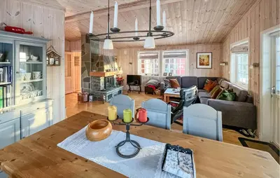 a kitchen and living room with a table and chairs at Stunning Home In Sjusjøen With Sauna in Sjusjøen