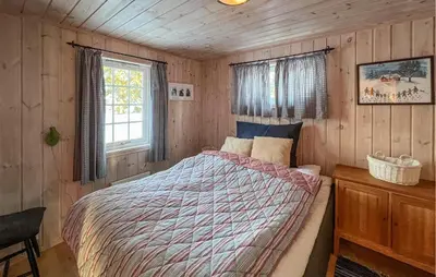 a bedroom with a bed in a wooden cabin at Stunning Home In Sjusjøen With Sauna in Sjusjøen