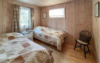 a bedroom with two beds and a chair in it at Stunning Home In Sjusjøen With Sauna in Sjusjøen