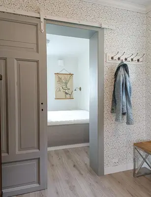 a bathroom with a sliding door with a bed in a room at Bellahuset - Charming House in Ulsteinvik in Ulsteinvik