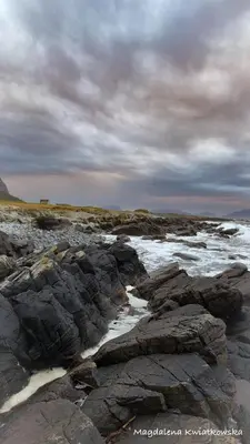 a beach with rocks and the ocean on a cloudy day at Bellahuset - Charming House in Ulsteinvik in Ulsteinvik