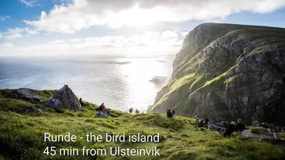 a group of people standing on a hill near the ocean at Bellahuset - Charming House in Ulsteinvik in Ulsteinvik