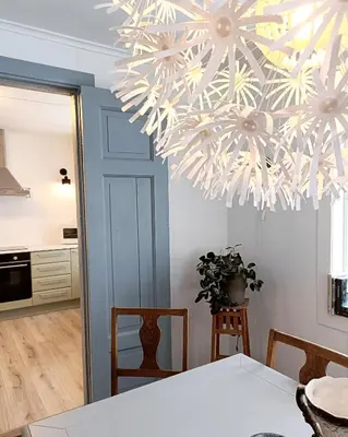 a dining room with a table and a chandelier at Bellahuset - Charming House in Ulsteinvik in Ulsteinvik