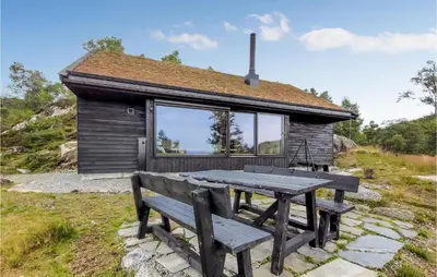 a picnic table and bench in front of a cabin at Beautiful Home In Jøsenfjorden in Gullingen