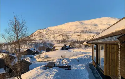 a cabin in the snow with a mountain in the background at Beautiful Home In Jøsenfjorden in Gullingen
