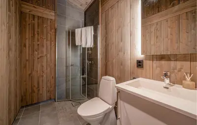 a bathroom with a toilet and a sink and a shower at 3 Bedroom Nice Home In Vøringsfoss in Maurset