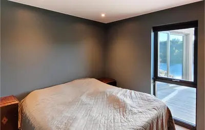 a bedroom with a bed and a large window at 5 Bedroom Lovely Home In Urangsvåg in Ervik