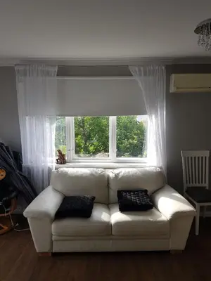 a white couch sitting in front of a window at Comfortable zone in Hønefoss