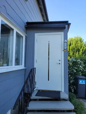 a white door on the side of a house at Comfortable zone in Hønefoss