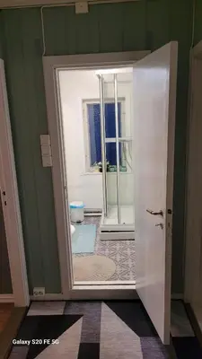 a bathroom with a door open to a toilet at Comfortable zone in Hønefoss
