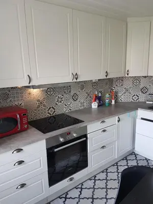 a kitchen with white cabinets and a stove top oven at Comfortable zone in Hønefoss