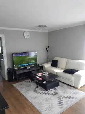 a living room with a white couch and a tv at Comfortable zone in Hønefoss