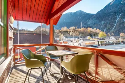 a balcony with a table and chairs and a view at Flåmsbrygga Apartments in Flåm