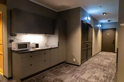 a kitchen with black cabinets and a microwave and a sink at Flåmsbrygga Apartments in Flåm