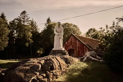 a statue of a man standing on top of a rock at Bekkjarvik Gjestgiveri in Bekkjarvik
