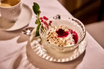 a dessert in a glass bowl on a plate on a table at Bekkjarvik Gjestgiveri in Bekkjarvik