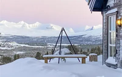 a bench in the snow next to a building at Awesome Home In Kvam With Sauna in Kvam