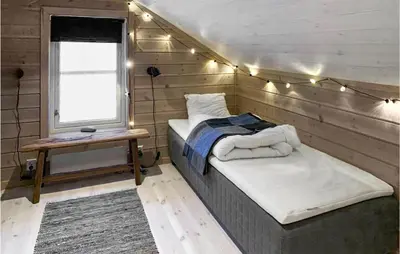 a bedroom with a bed and a window with lights at Awesome Home In Kvam With Sauna in Kvam
