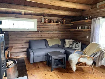 a living room with a blue couch in a cabin at Maurtua - cabin in lovely surroundings in Kvam