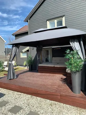 a wooden deck with a black umbrella on a house at Private house in Orkanger, 35 minutes from Trondheim in Orkanger