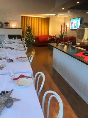 a long row of tables in a restaurant with a christmas tree at Førde Pensjonat in Førde