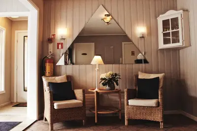 a room with two chairs and a table with a mirror at Førde Pensjonat in Førde