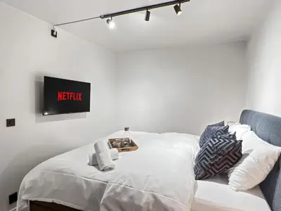 a bedroom with a bed and a tv on the wall at King bed - Behind Bryggen - Renovated des 23 in Bergen