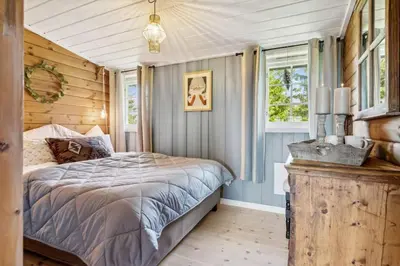 a bedroom with a bed and a window at Cozy and comfortable cabin in the center of Sjusjøen with a large terrace in Ringsaker