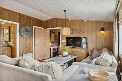 a living room with two couches and a tv at Cozy and comfortable cabin in the center of Sjusjøen with a large terrace in Ringsaker