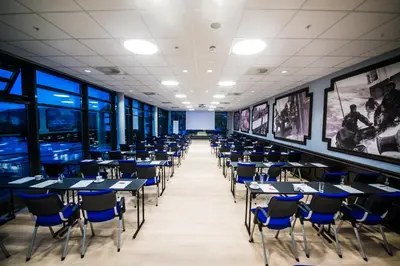 a dining room with tables and blue chairs at Thon Hotel Fosnavåg in Fosnavåg