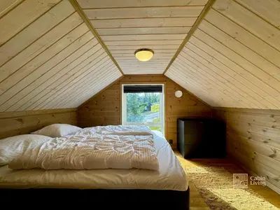 a bedroom with a large bed in a attic at Cozy cabin on Sjusjølia by the trail network sauna in Ringsaker