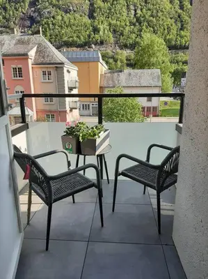 a balcony with two chairs and a table with a plant at Apartment 2 sleeping rooms in Rjukan in Rjukan