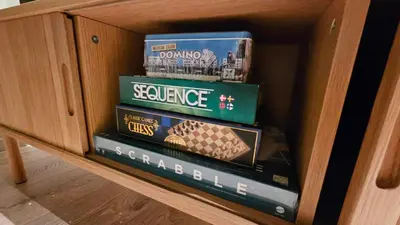 a wooden cabinet with some books in a drawer at West Coast Apartments Aalesund in Ålesund