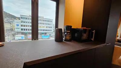 a kitchen counter with a view of a city from a window at West Coast Apartments Aalesund in Ålesund