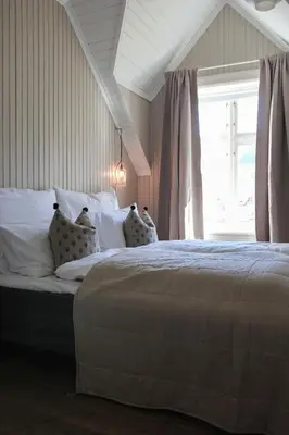 a bedroom with a large bed with a window at Petrines Gjestgiveri in Norddal