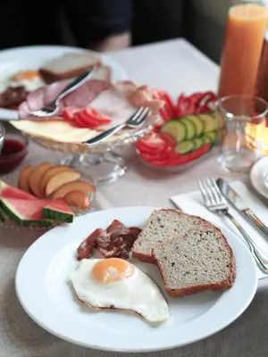 a plate of food with an egg and bread on a table at Petrines Gjestgiveri in Norddal