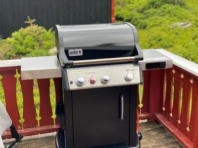 a grill sitting on top of a deck at Høstkos og ro på Budor, 4 roms hytte med peis og wifi in Nordset