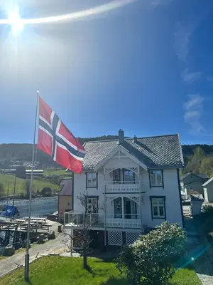 a house with a british flag in front of it at Handelsmannens hus ved Otnesbrygga, Valsøyfjord in Otnes