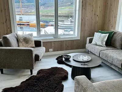 a living room with two couches and a table at Handelsmannens hus ved Otnesbrygga, Valsøyfjord in Otnes