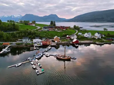 an aerial view of a harbor with boats in the water at Handelsmannens hus ved Otnesbrygga, Valsøyfjord in Otnes