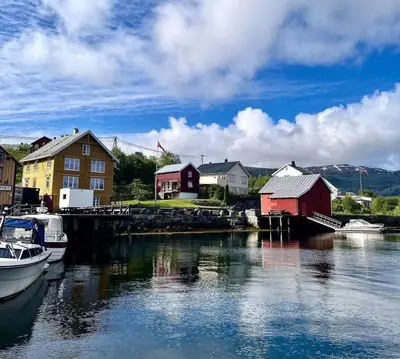 a group of houses and boats in a body of water at Hus ved Valsøyfjorden in Otnes