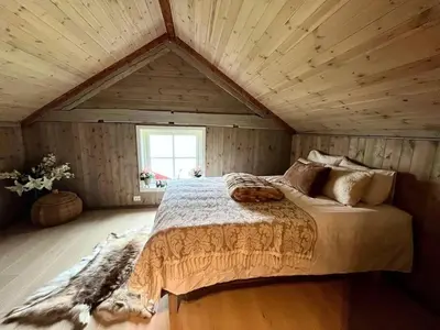 a bedroom with a large bed in a attic at Hus ved Valsøyfjorden in Otnes