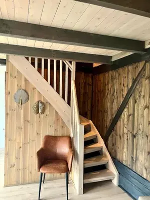 a wooden staircase in a room with a brown chair at Hus ved Valsøyfjorden in Otnes