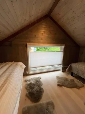 a room with a bed and a window in a attic at Hus ved Valsøyfjorden in Otnes